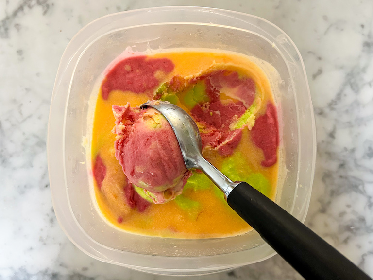 Ice cream scoop scooping homemade rainbow sherbet 