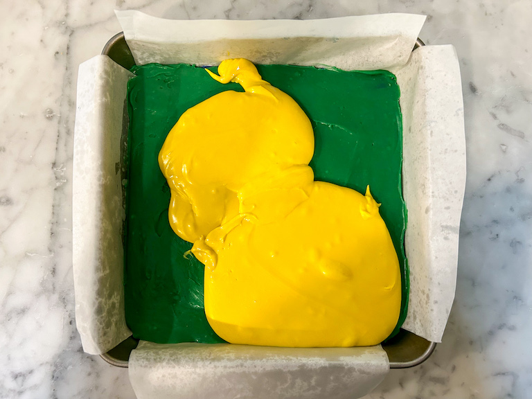 Yellow fudge layered over green fudge in a square tin