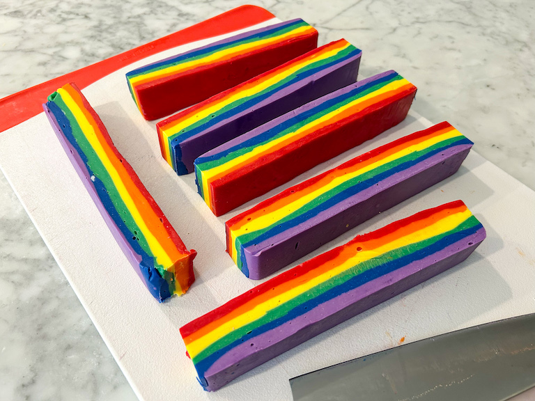 Slices of rainbow fudge on a cutting board