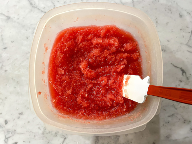 Stirring watermelon granita with a rubber spatula