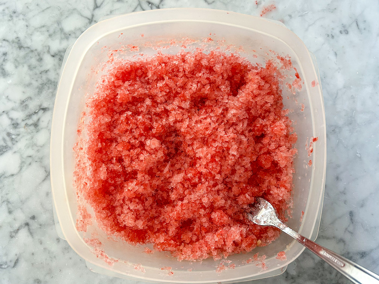 Breaking watermelon granita apart with a fork
