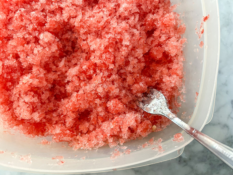 Breaking apart watermelon granita with a fork
