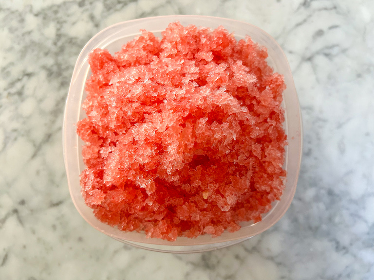 A plastic container of watermelon granita