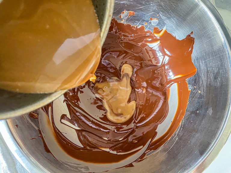 Pouring cream and cola mixture into melted chocolate