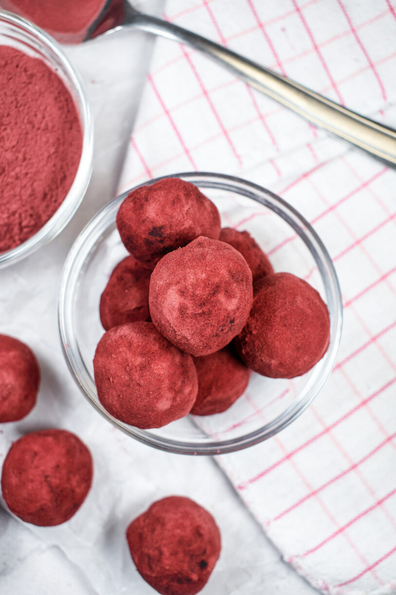 Looking down at a bowl of beet and chocolate truffles positioned on a pink checkered towel