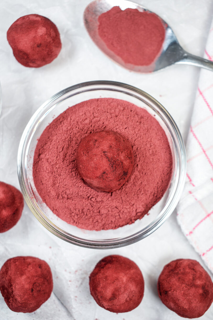 A bowl of powdered beets with a truffle sitting in the middle