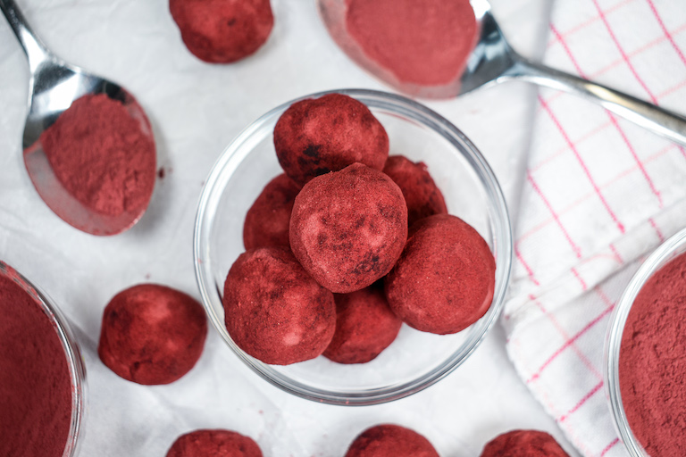 A bowl of beetroot truffles arranged on a white surface