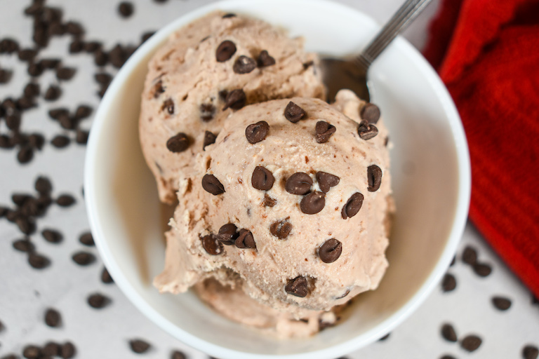 Looking down at a dish of cherry ice cream garnished with chocolate chips