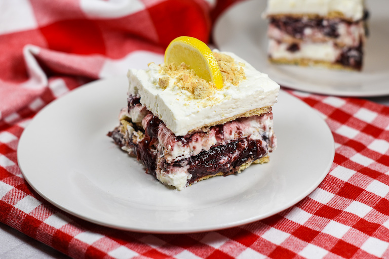 A slice of cherry cheesecake icebox cake on a plate