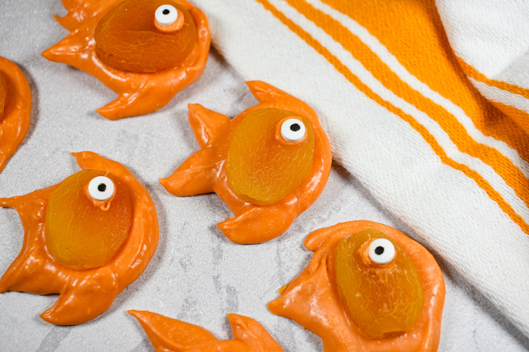 Chocolate apricot goldfish arranged on a white surface with a striped towel