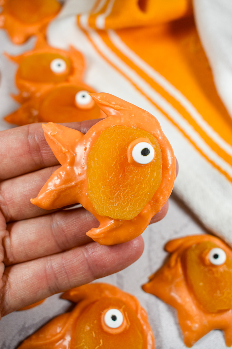 Hand holding an orange chocolate goldfish