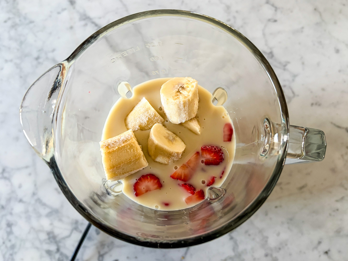 Peanut butter and jelly smoothie ingredients in a blender