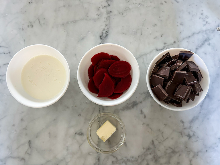 Beet and chocolate truffle ingredients arranged on a marble surface