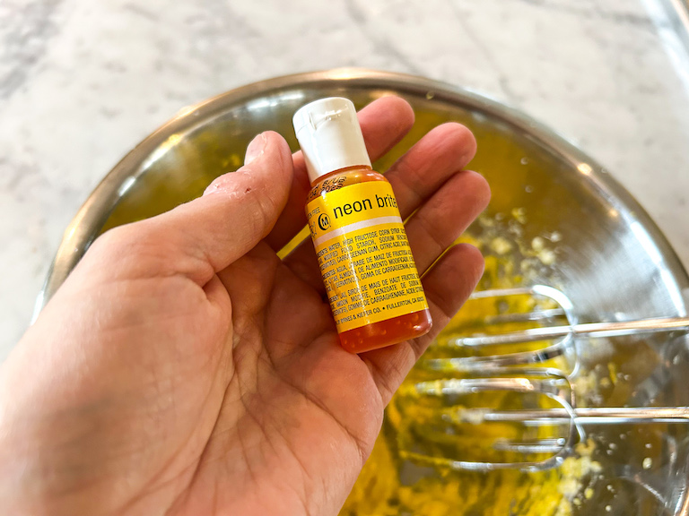 Hand holding a bottle of yellow food coloring