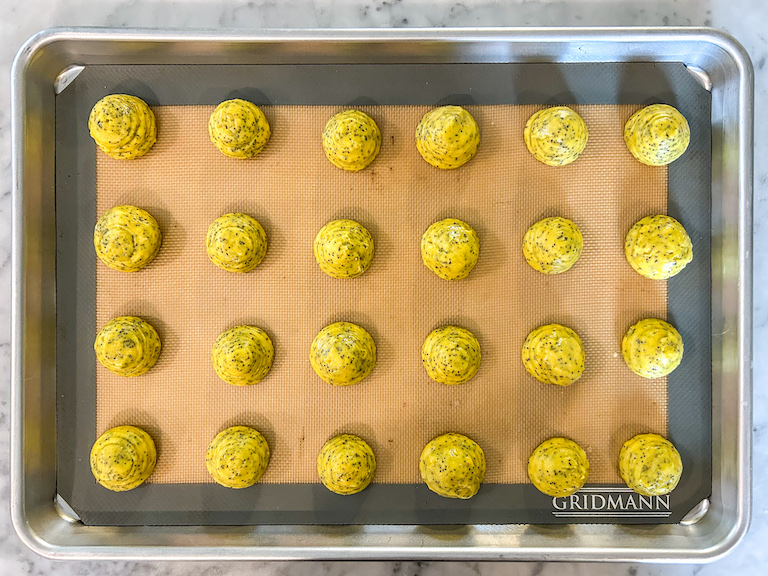 Piped lemon whoopie pie batter on a tray