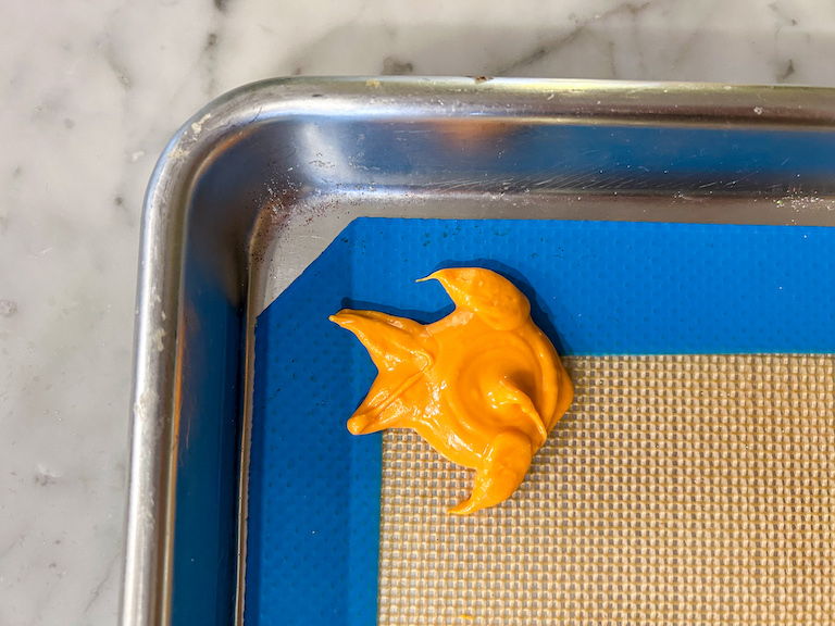 Piped orange chocolate fish on a tray