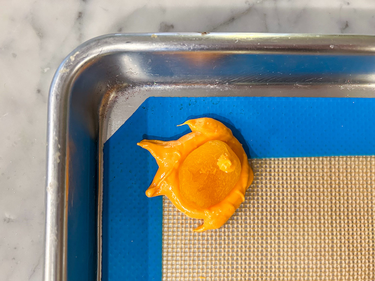 Chocolate orange goldfish on a silicone mat, decorated with a dried apricot