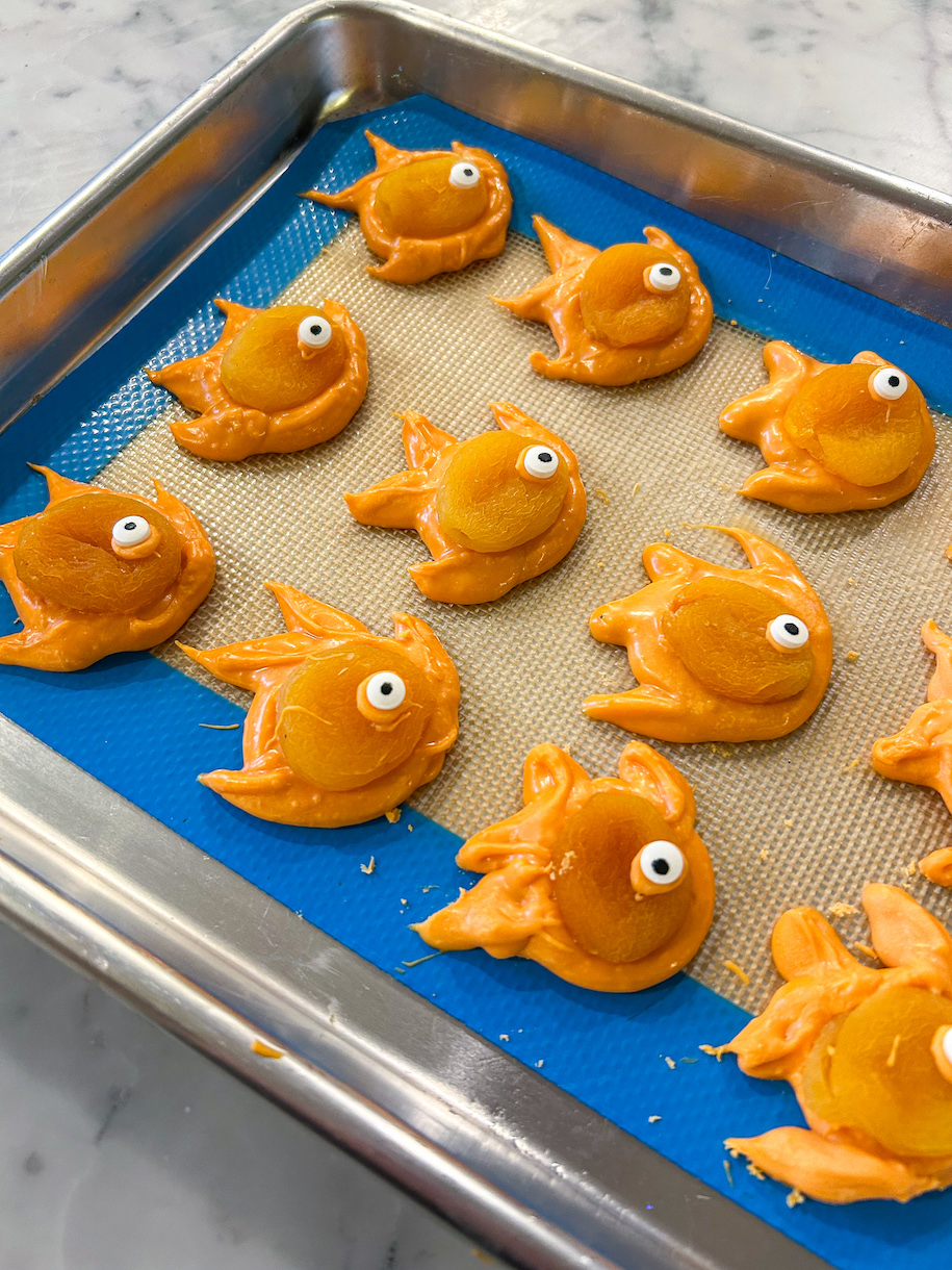 Tray of piped orange goldfish decorated with apricots and candy eyeballs