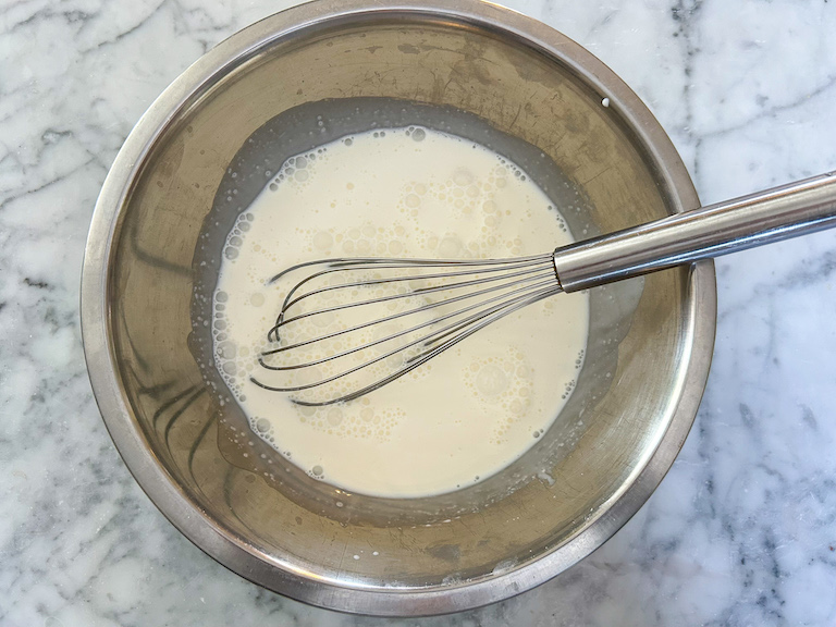 milk and cream in a bowl with a whisk