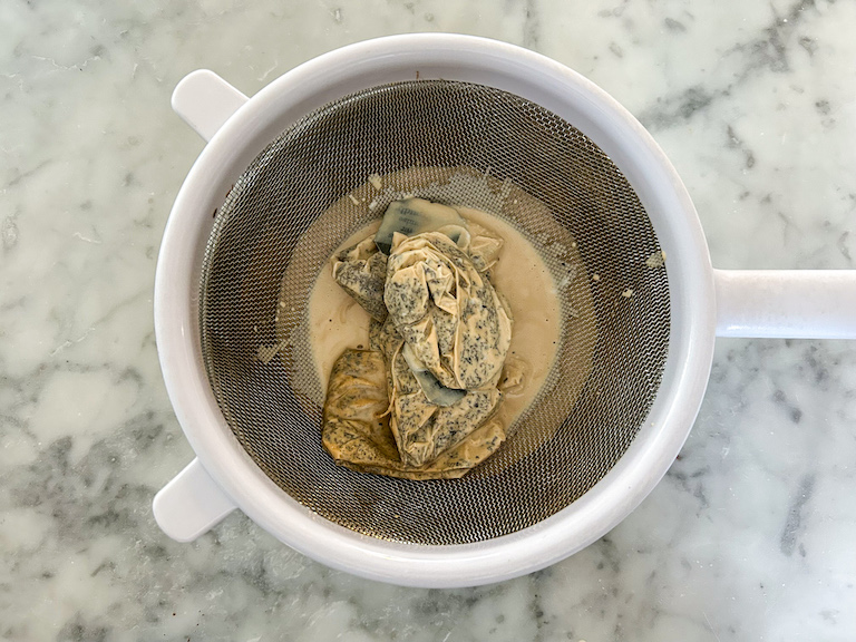 Passing tea bags through a fine mesh strainer