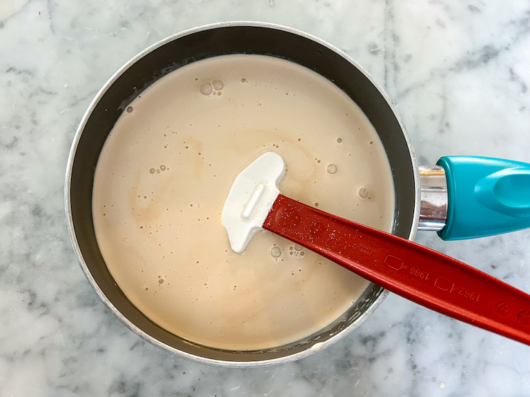 Ice cream base in a small saucepan with a rubber spatula