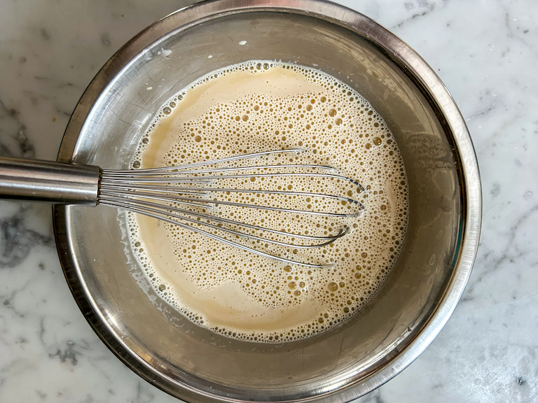 Whisking ice cream base in a metal bowl