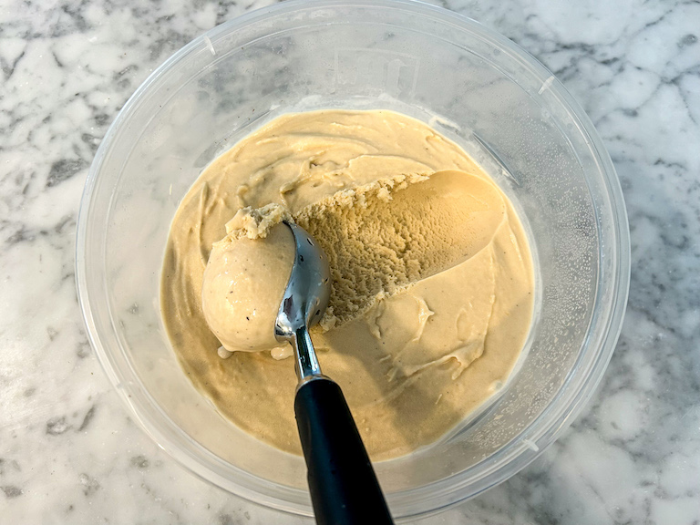 A container of Earl Grey tea ice cream with an ice cream scoop