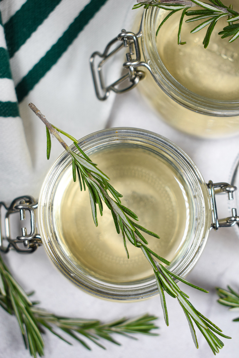 jars of rosemary syrup with fresh herbs