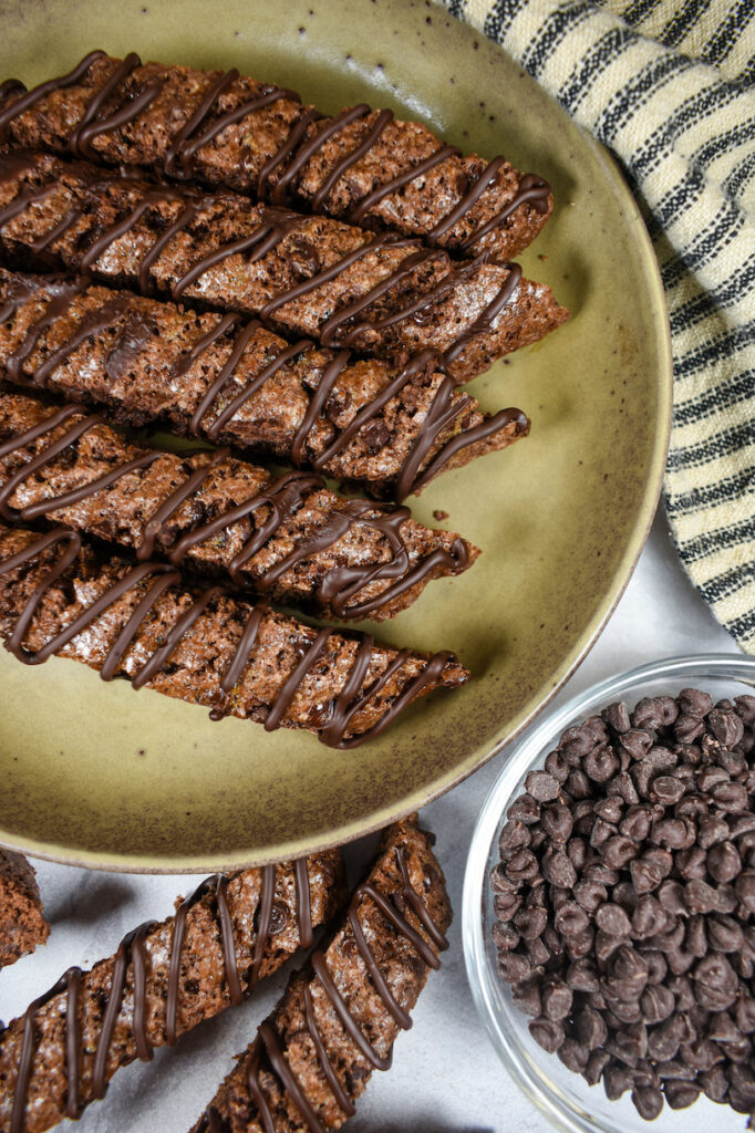 a plate of double chocolate biscotti and a dish of chocolate chips