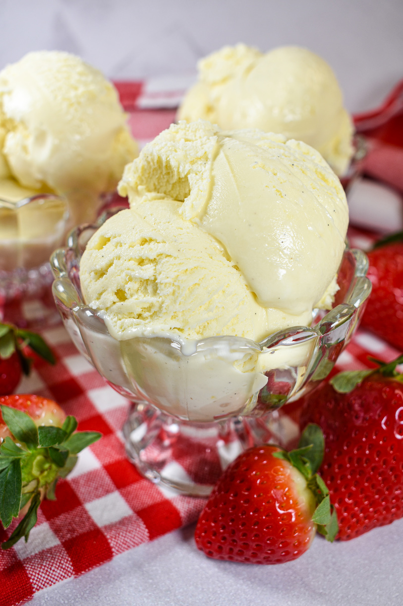 A dish of cheesecake ice cream with fresh strawberries
