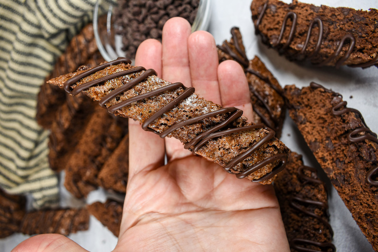 Hand holding a chocolate biscotti cookie