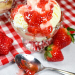 a dish of cheesecake ice cream with strawberry compote, surrounded by fresh berries