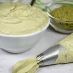 Dish of matcha whipped cream and a piping bag of whipped cream