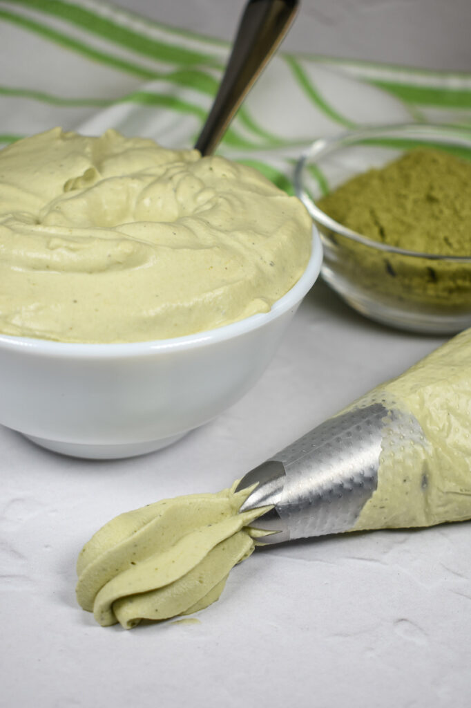 Dish of matcha whipped cream and a piping bag of whipped cream