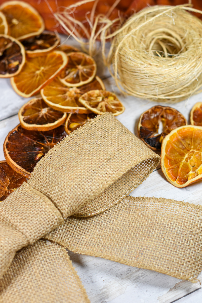 A dried orange slice wreath with a bow and a spool of twine