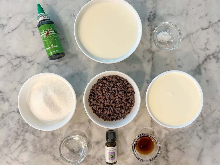 Mint chocolate chip ice cream recipe ingredients arranged on a marble surface