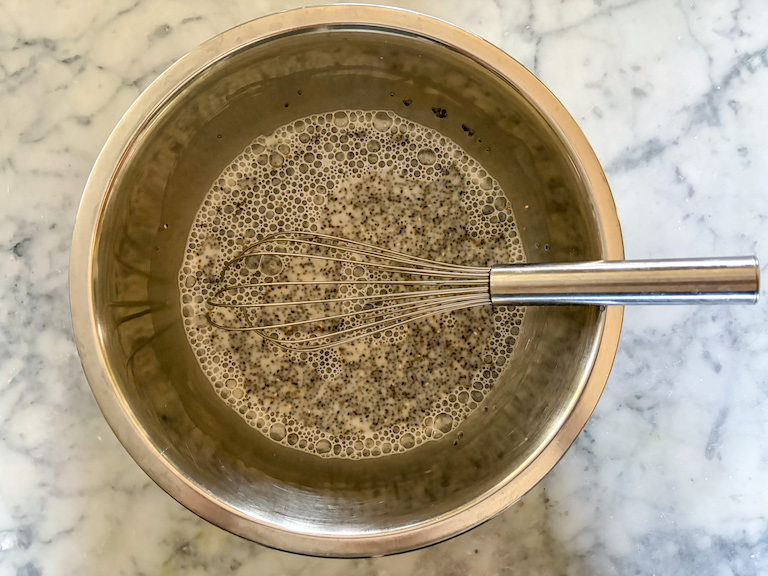 whisking chia seeds and almond milk in a metal bowl