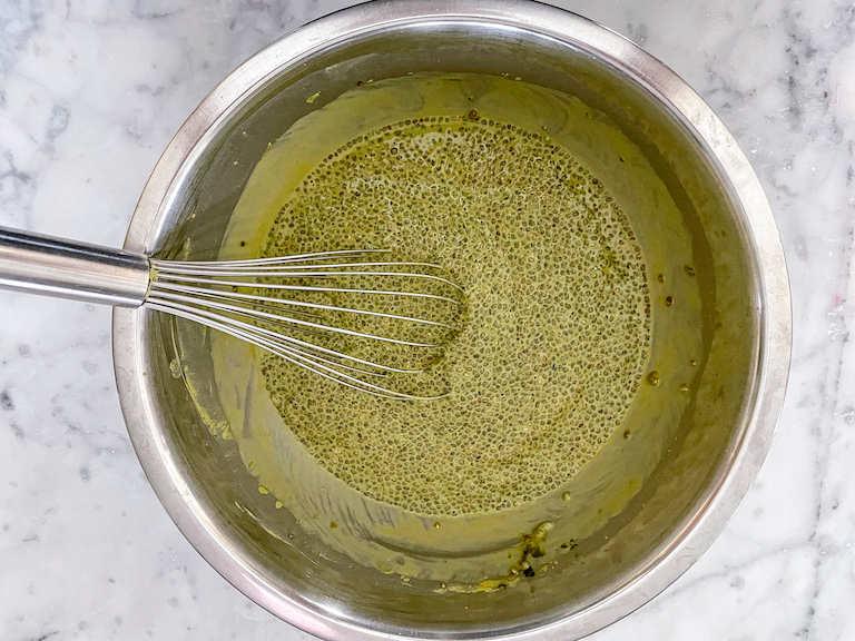 Matcha chia pudding in a bowl with a whisk