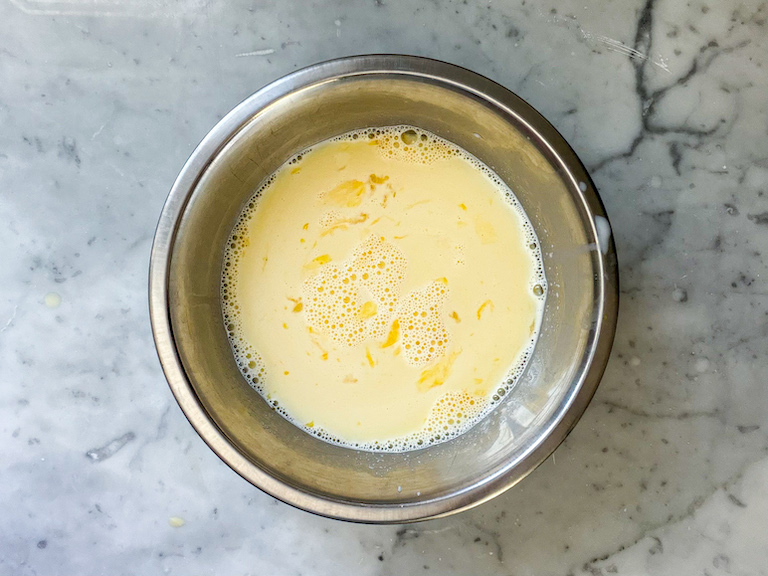 Tempering hot ice cream base into egg yolks