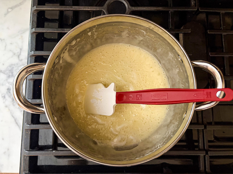 Melted butter and marshmallow mixture in a pot on the stovetop with a spatula
