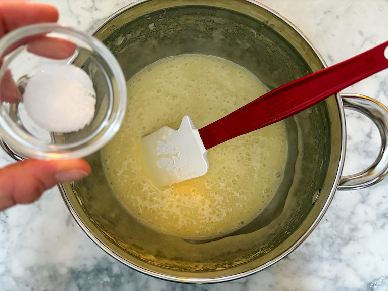 Adding salt to a pot of melted butter and marshmallow