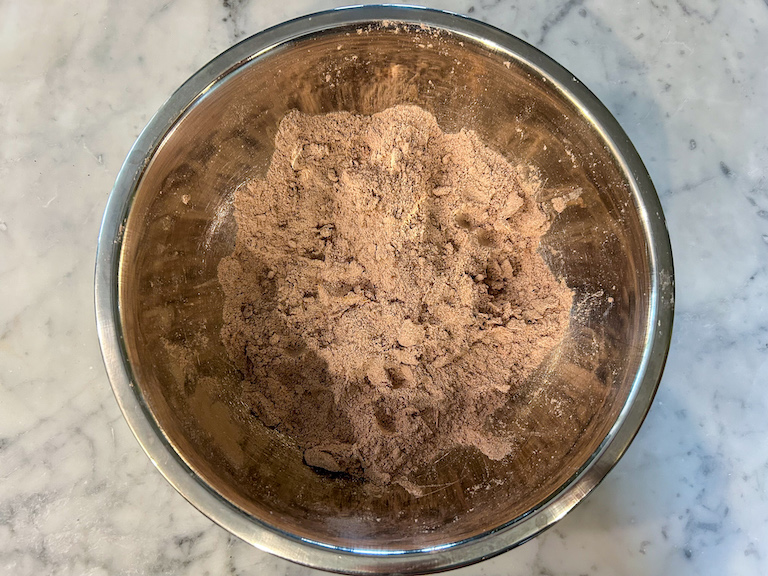 Rubbing butter into a bowl of cocoa and flour