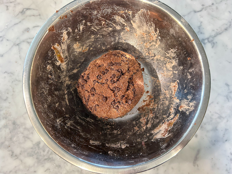 A ball of chocolate biscotti dough in a bowl