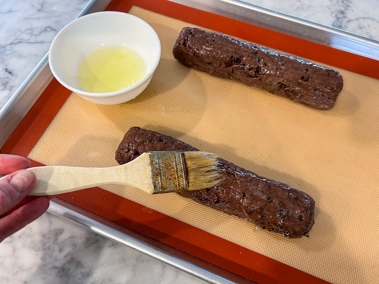 Brushing biscotti logs with egg white