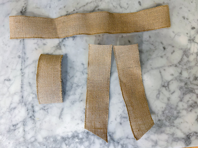 Burlap ribbon pieces arranged on a marble surface