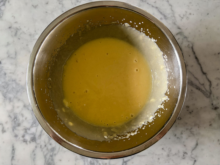 Wet ingredients in a metal mixing bowl