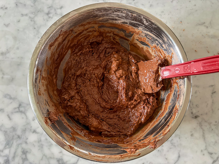 Chocolate muffin batter in a bowl with a spatula