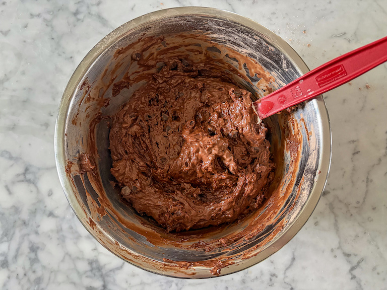 Chocolate muffin batter in a bowl with a spatula
