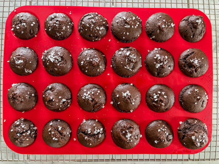 A pan of chocolate mini muffins cooling on a wire rack