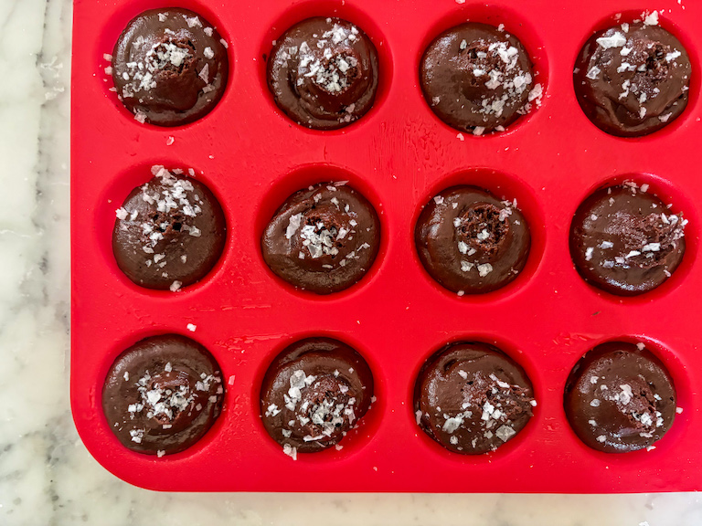 Red silicone muffin pan filled with chocolate muffin batter